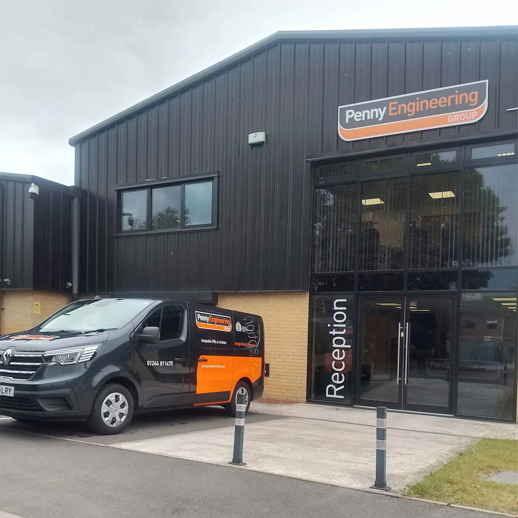 A black and orange van with Penny Engineering Group branding is parked outside a modern industrial building. The building has large windows and a sign that says Reception by the entrance.