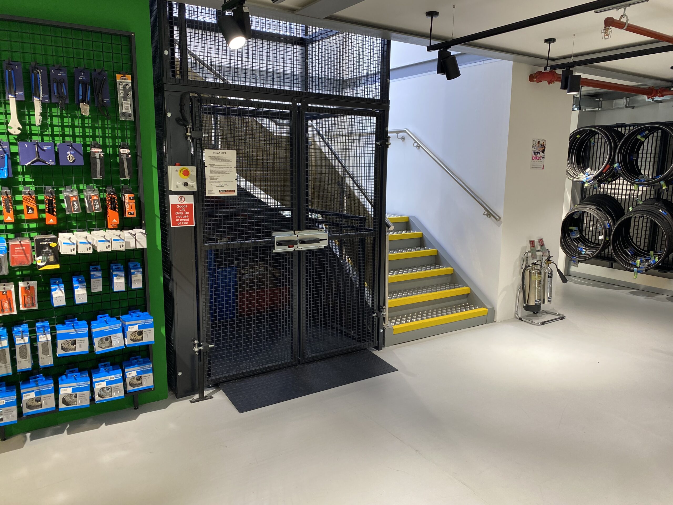 A distorted digital image of a modern office space with desks, chairs, and computers. The image is split into colourful sections with green, blue, and yellow hues, and pixelated glitches obscuring much of the scene.